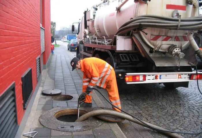 Action Septic technician servicing a septic system with a vacuum truck